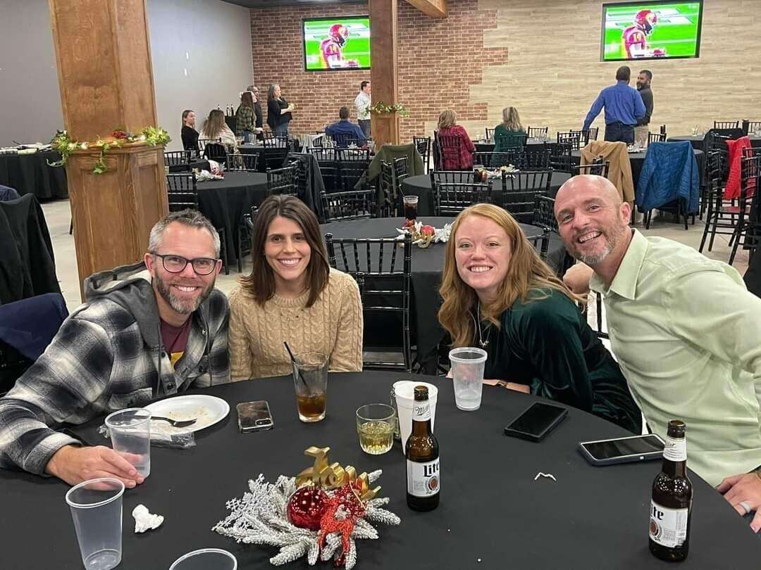 Tony, Winn, and their wives enjoying a drink together.